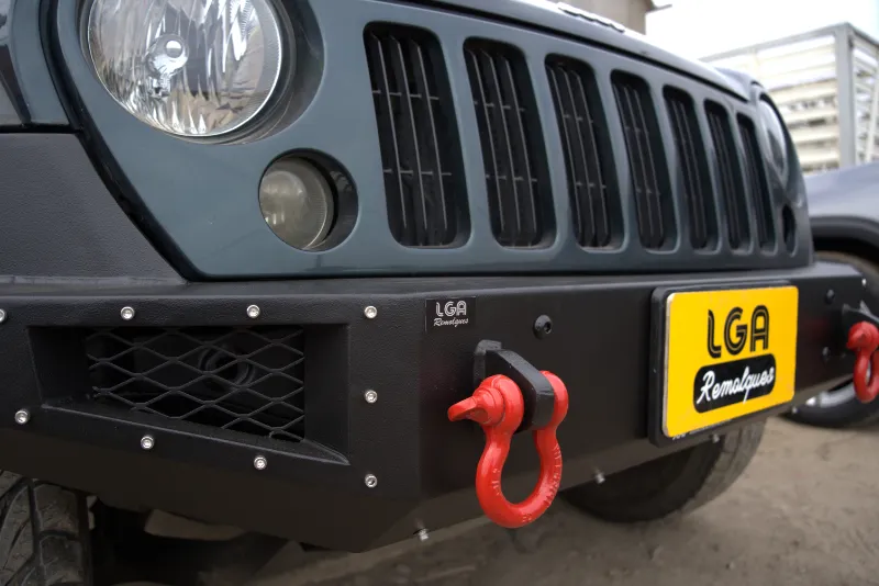 Detalle de bumper frontal negro con grilletes rojos en un Jeep Wrangler