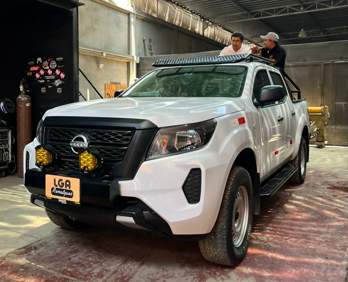 El equipo de LGA revisando una pickup Nissan con parrilla de techo en el taller