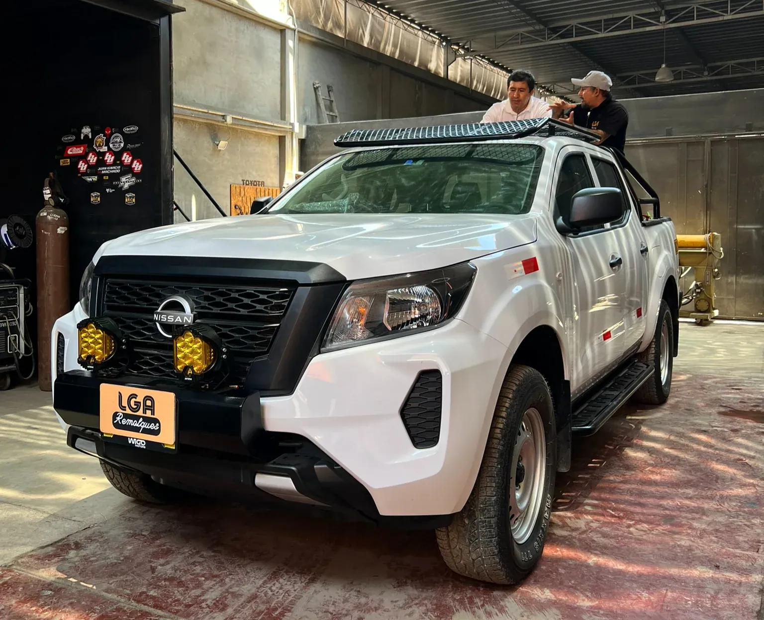White Nissan pickup with installed equipment inside the LGA workshop